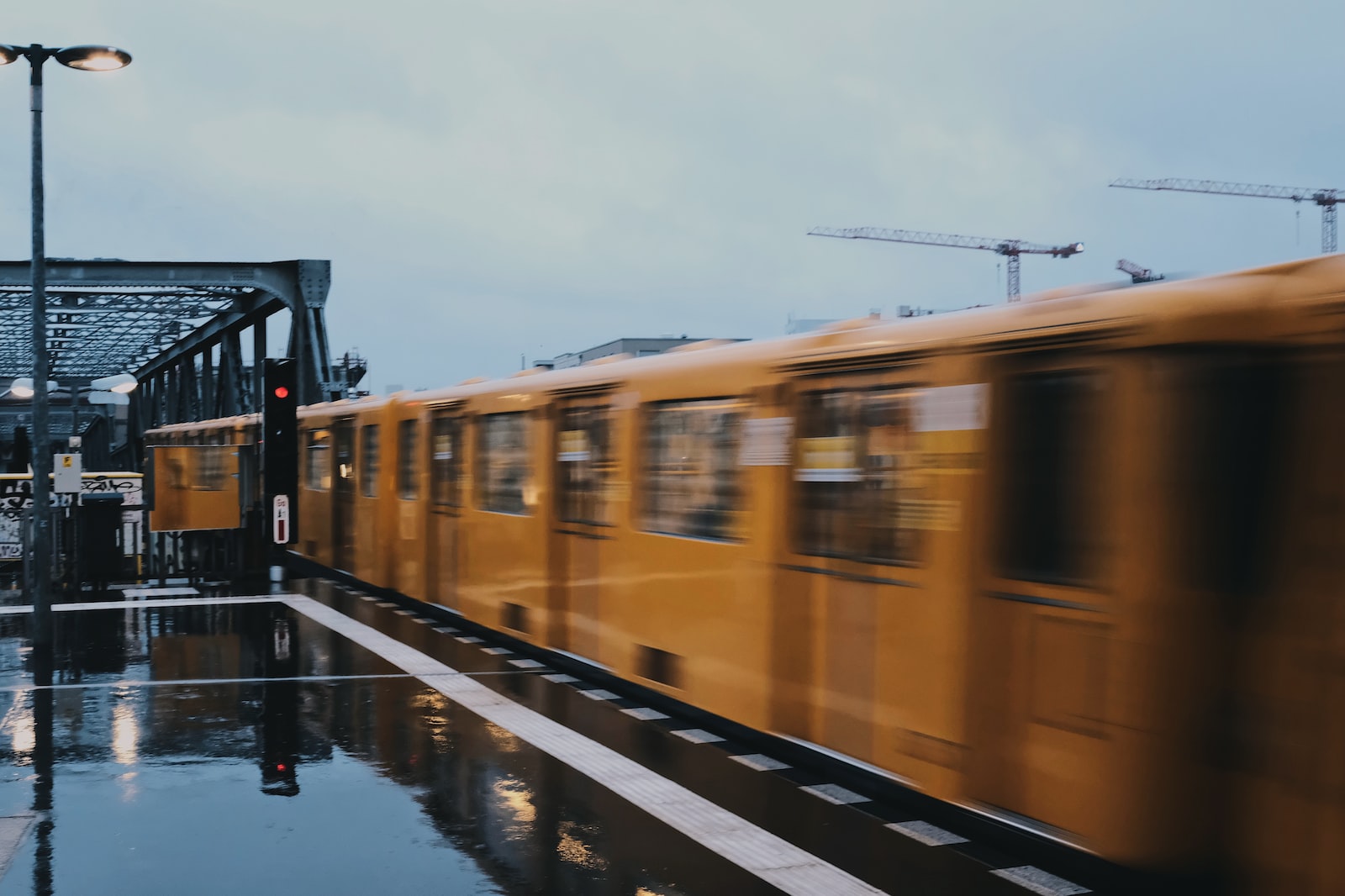 Blurry yellow ubahn moving outside under a grey sky