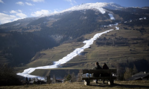 White ski slope down along a brown mountain landscape