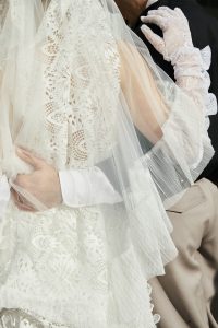 wedding couple from behind, zoomed in on the dress and interlinked arms