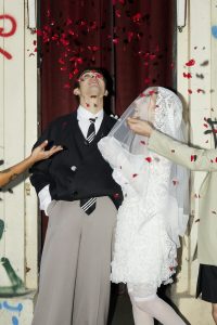 wedding couple standing under a rain of flower pattels