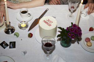 'just married' wedding cake on a messy table