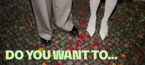 wedding couple standing on rose pettals - below the writing "do you want to..."