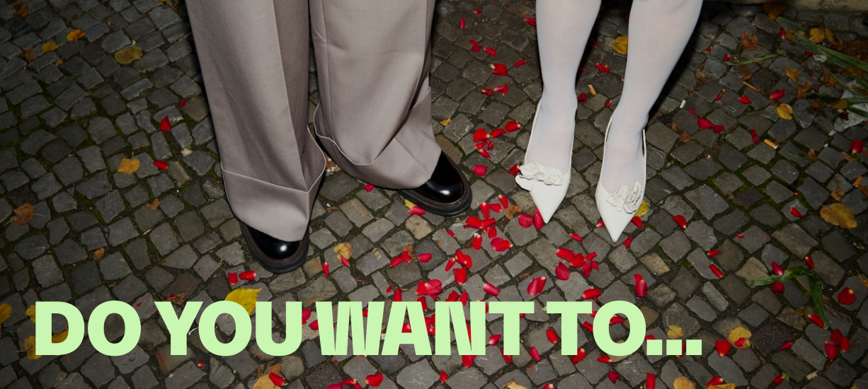 wedding couple standing on rose pettals - below the writing "do you want to..."